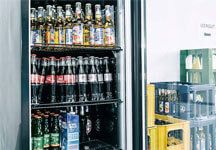 Getränkekühlschrank Getränkekühlschrank befüllt mit unterschiedlichen Getraenken wie Cola und Apfelschorle