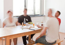Arbeitsatmosphäre verschieden Personen sitzen beim Mittagessen zusammen im Sozialraum, es solle eine gute Arbeitsatmosphäre vermitteln